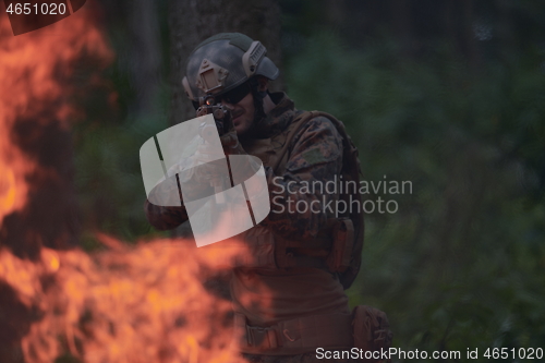 Image of soldier in action aiming  on weapon  laser sight optics