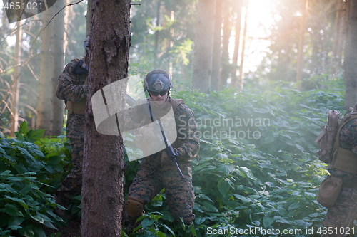 Image of soldier in action aiming  on laser sight optics