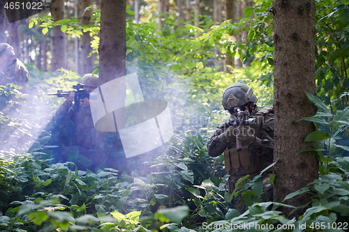 Image of soldier in action aiming  on weapon  laser sight optics