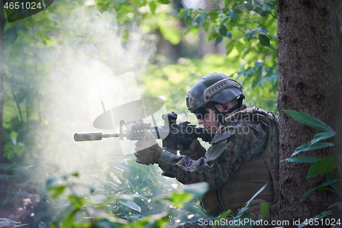 Image of soldier in action aiming  on weapon  laser sight optics