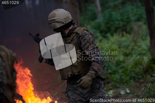 Image of Soldier in Action at Night jumping over fire