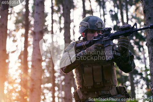 Image of soldier in action aiming  on weapon  laser sight optics