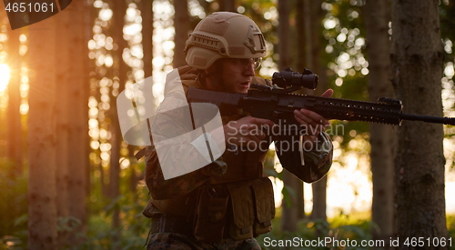 Image of soldier in action aiming  on weapon  laser sight optics