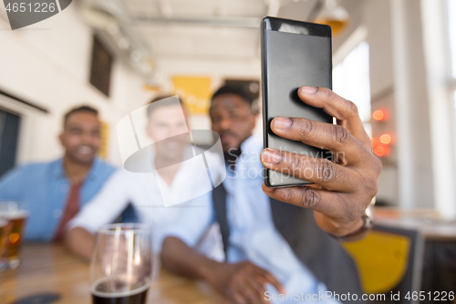 Image of friends taking selfie and drinking beer at bar