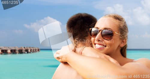 Image of happy couple hugging on summer beach