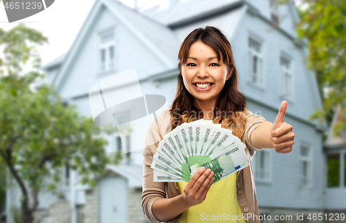 Image of asian woman with euro money showing thumbs up
