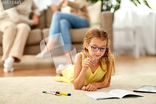 Image of student girl writing to notebook at home