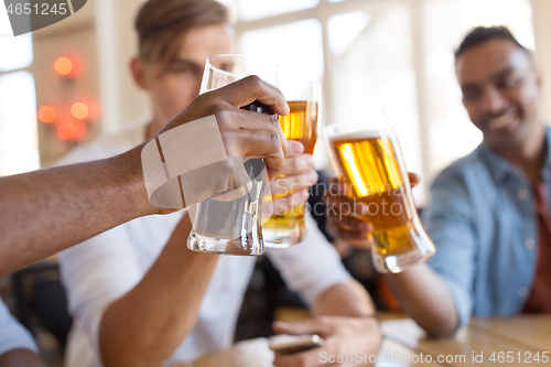 Image of happy male friends drinking beer at bar or pub
