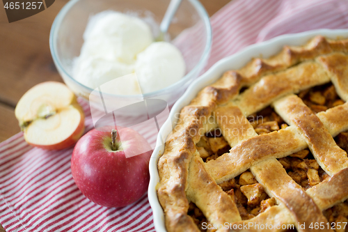 Image of apple pie with ice cream on wooden table