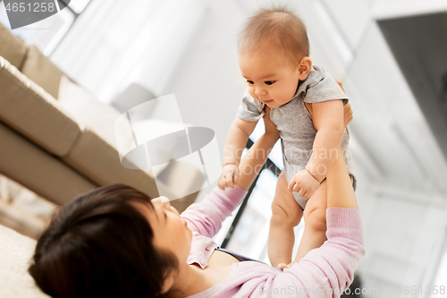 Image of happy young mother with little baby son at home