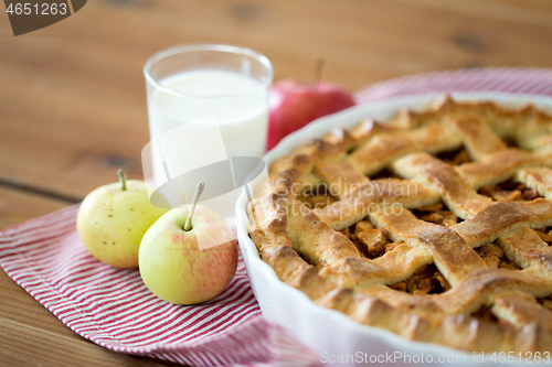 Image of apple pie in baking mold on wooden table