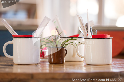 Image of close up of cups with cutlery on restaurant table