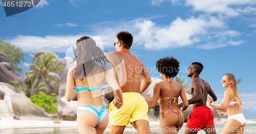 Image of happy friends running on summer beach