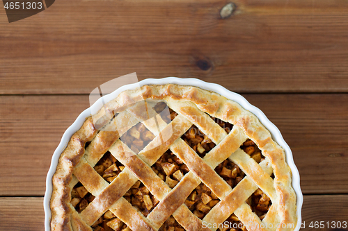Image of close up of apple pie in mold on wooden table