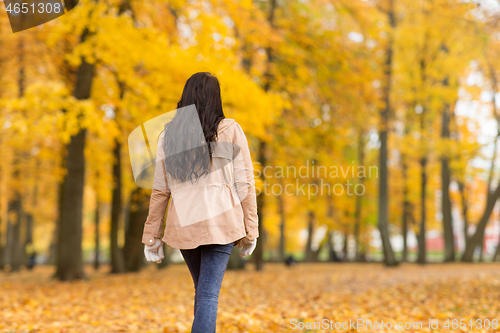 Image of young woman walking in autumn park