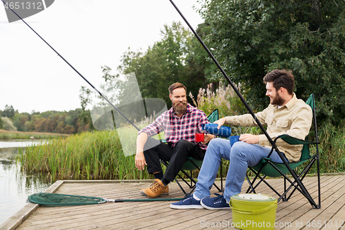 Image of friends fishing and drinking tea from thermos