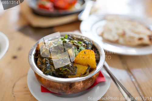 Image of close up of aloo palak dish in bowl on table