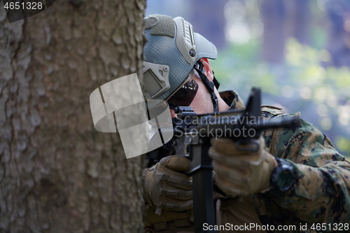 Image of soldier in action aiming  on weapon  laser sight optics