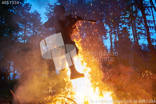 Image of Soldier in Action at Night jumping over fire