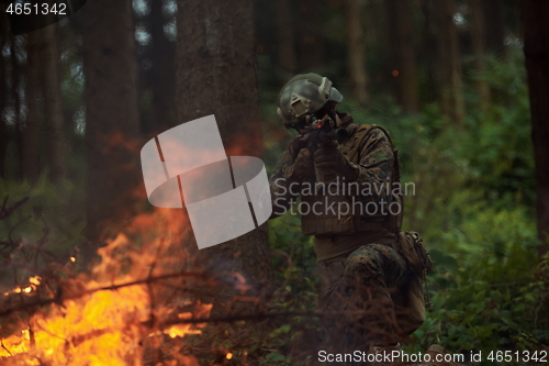 Image of soldier in action aiming  on weapon  laser sight optics