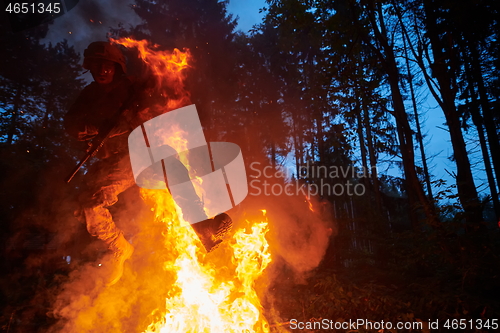 Image of Soldier in Action at Night jumping over fire