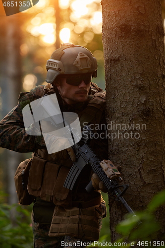 Image of soldier in action aiming  on weapon  laser sight optics