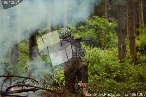 Image of soldier in action aiming  on weapon  laser sight optics