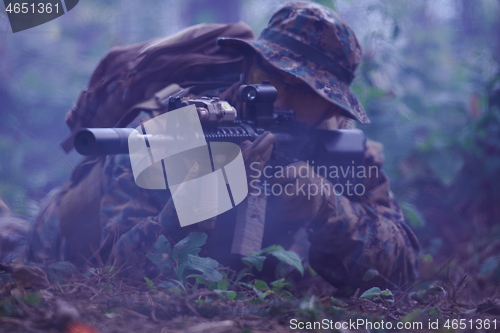 Image of soldier in action aiming  on weapon  laser sight optics