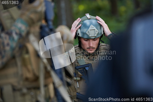 Image of soldier preparing tactical and commpunication gear for action ba