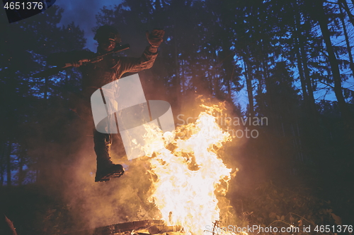 Image of Soldier in Action at Night jumping over fire