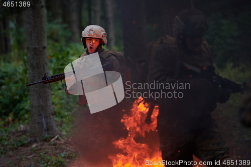 Image of Soldier in Action at Night jumping over fire