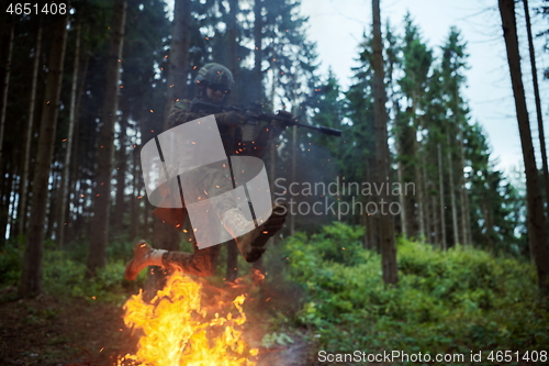 Image of Soldier in Action at Night jumping over fire