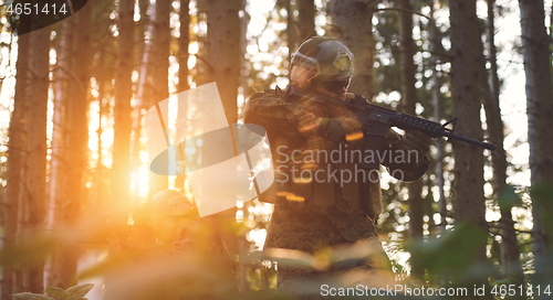 Image of soldier in action aiming  on weapon  laser sight optics