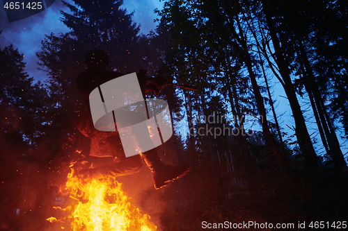 Image of Soldier in Action at Night jumping over fire