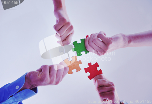 Image of Group of business people assembling jigsaw puzzle