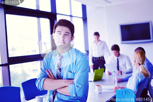 Image of business man  on a meeting in offce with colleagues in backgroun