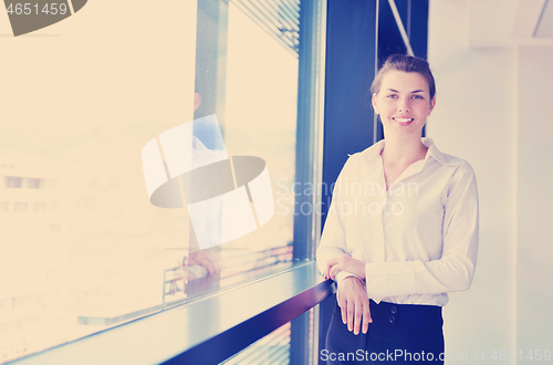 Image of business woman with her staff in background at office