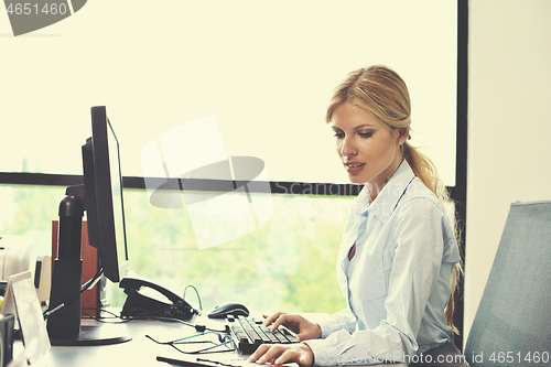 Image of business woman working on her desk in an office