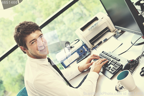 Image of happy young business man at office