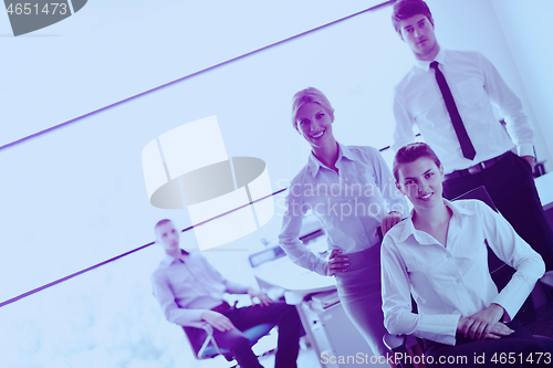 Image of business woman with her staff in background at office