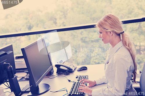 Image of Young pretty business woman with notebook in the office