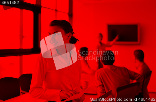 Image of business woman with her staff in background at office