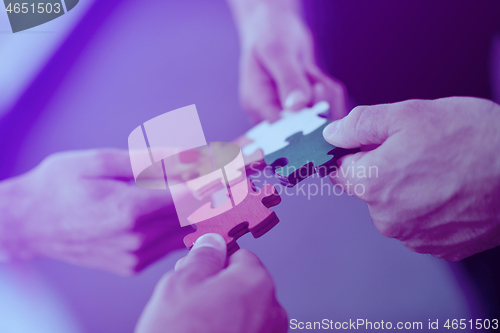 Image of Group of business people assembling jigsaw puzzle