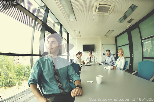 Image of business man  on a meeting in offce with colleagues in backgroun