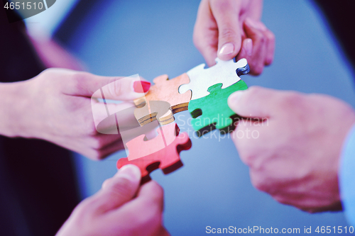 Image of Group of business people assembling jigsaw puzzle