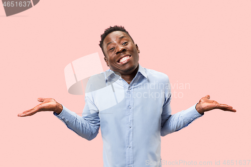 Image of The happy businessman standing and smiling against pink background.