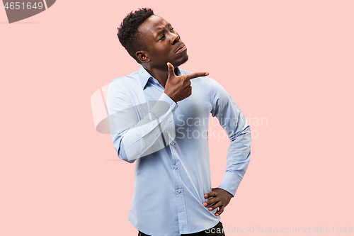 Image of The young attractive man looking suprised isolated on pink