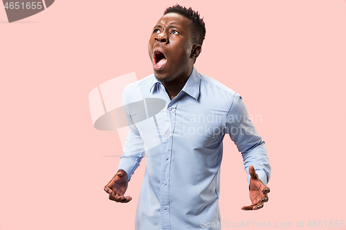 Image of The young emotional angry man screaming on pink studio background