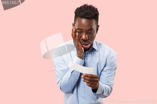 Image of Young boy with a surprised expression bet slip on blue background