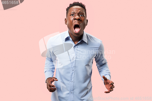 Image of The young emotional angry man screaming on pink studio background